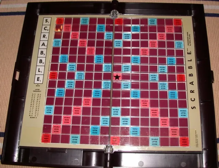 Tablero de Scrabble abierto con la rejilla de 15x15 y las casillas de premio en rojo, azul y rosa.